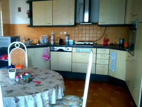 A kitchen with a dining table and wooden cabinets. - image 8