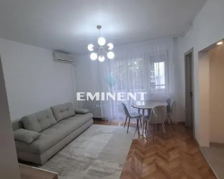 Living room with a sofa, dining table, and parquet flooring. - image 12
