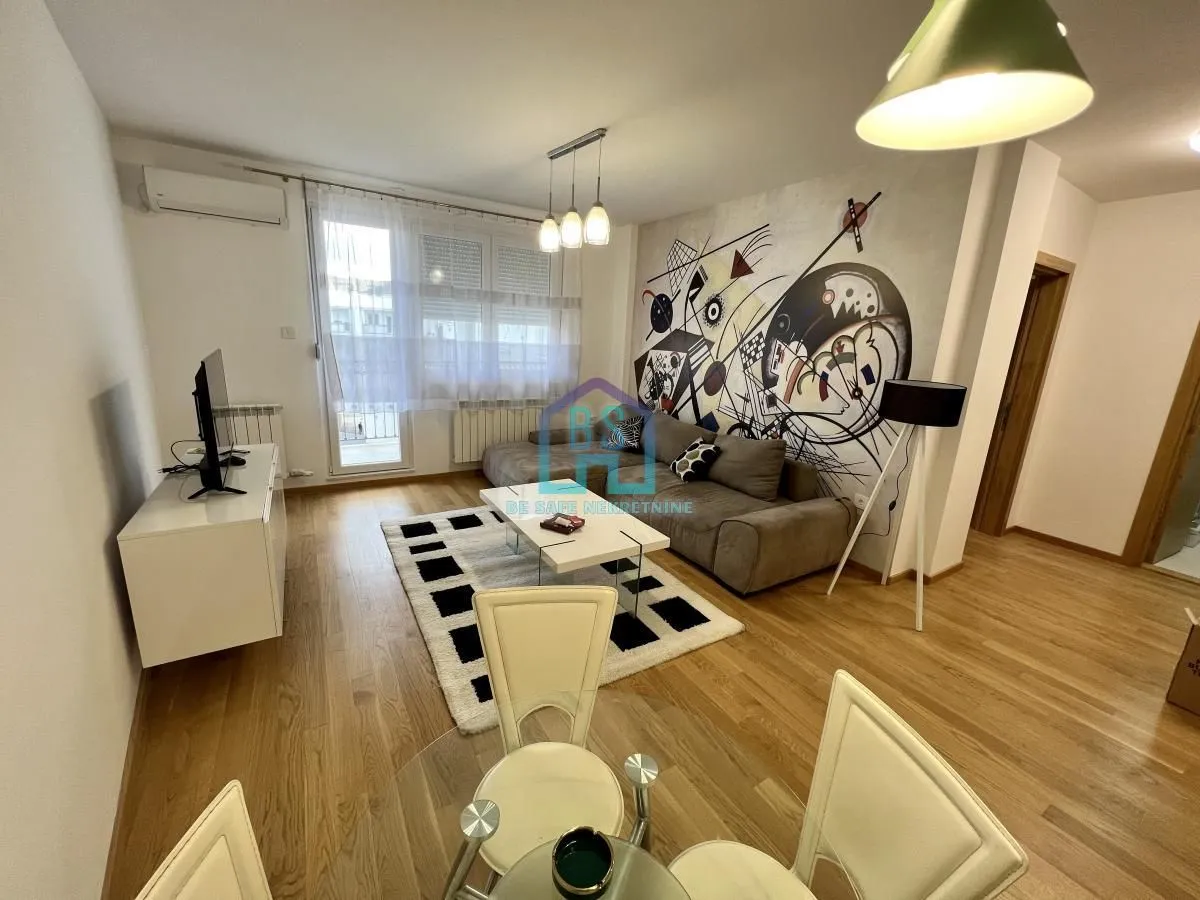 Living room with a sofa, TV, and dining table.