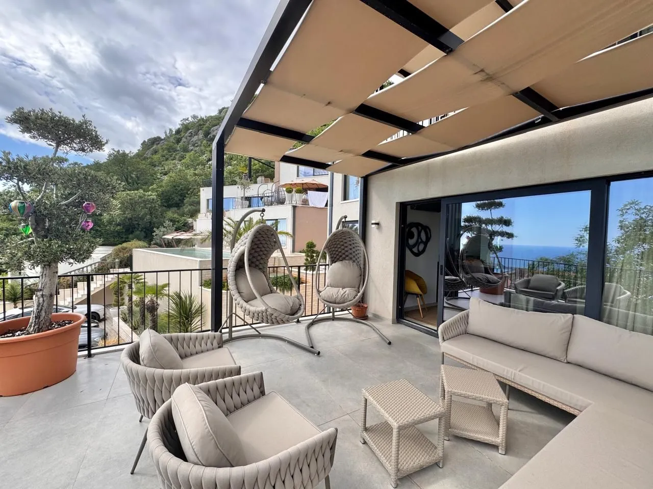 Modern and spacious terrace with seating furniture and a sea view.