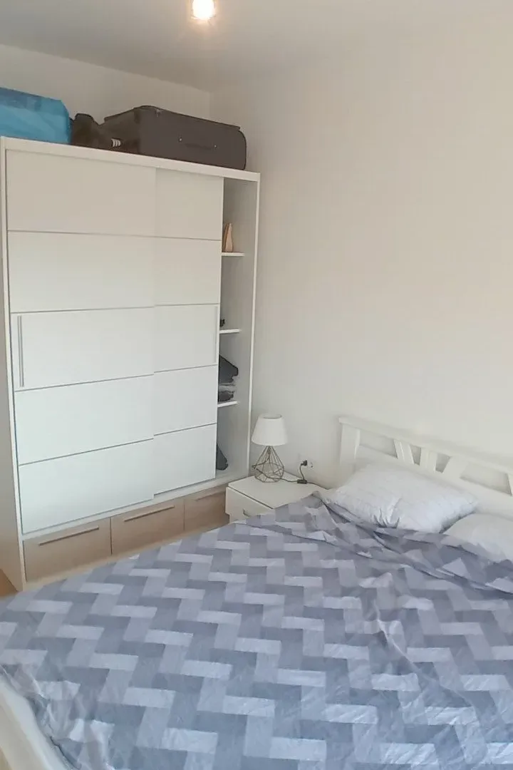 Bedroom with a double bed and a white wardrobe.