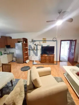 Living room with sofa, television and kitchen in the background. - image 3