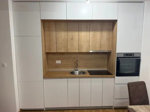 Modern kitchen with white cabinetry and wooden details. - image 9