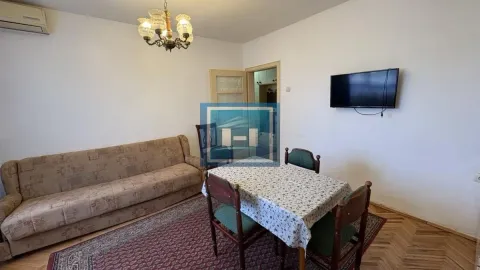 Dnevna soba sa garniturom za sedenje, trpezarijskim stolom i televizorom na zidu. - image 4