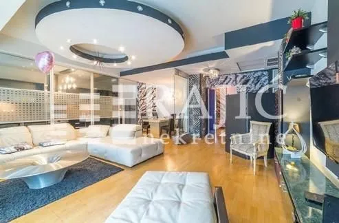 Spacious and modern living room with a sofa and a dropped ceiling.