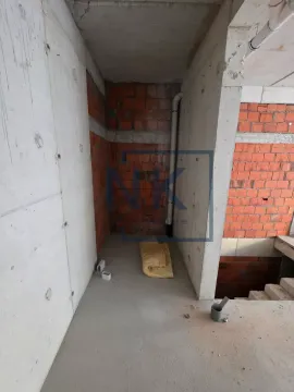 View of a property in a grey phase of construction with exposed brick and concrete walls. - image 4