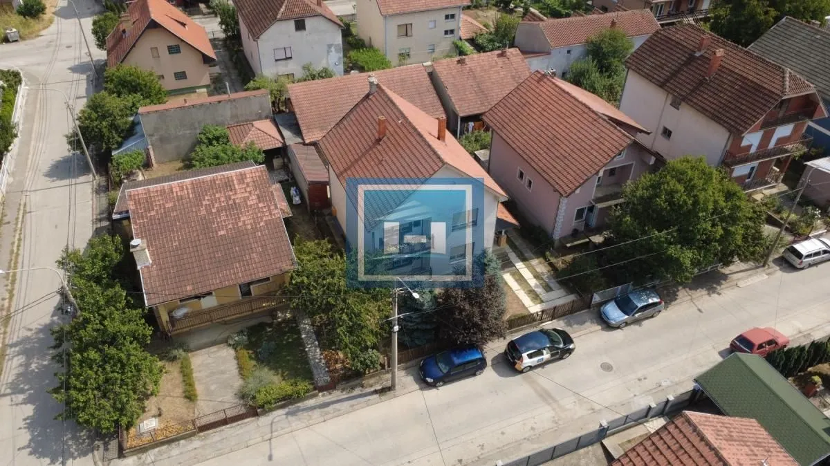 Pogled iz vazduha na kuću i okolno naselje sa ulicom.