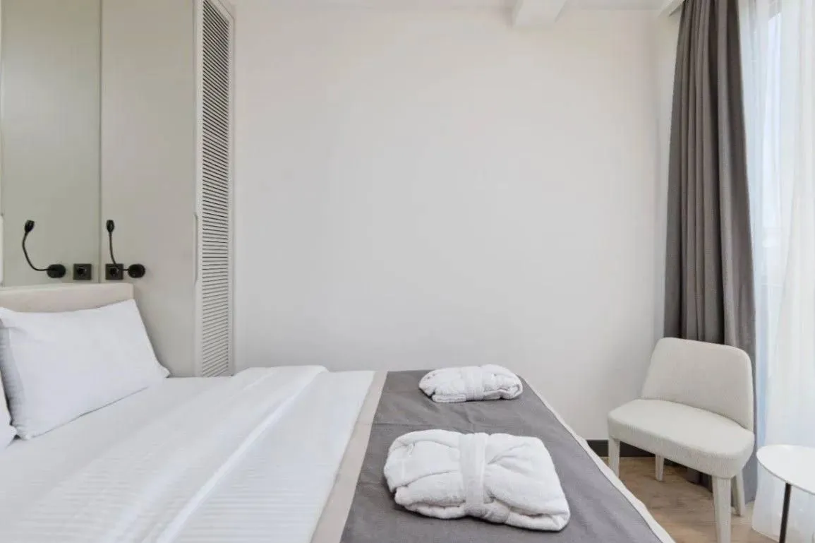 Moderna spavaća soba sa bračnim krevetom, foteljom i garderoberom.