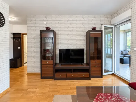 Dnevna soba sa garniturom za TV i pogledom na terasu. - image 4