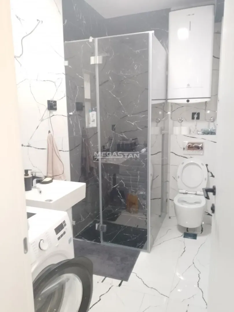 Moderno opremljeno kupatilo sa tuš kabinom, umivaonikom i wc šoljom.