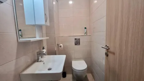 Small tiled bathroom with a sink and a toilet. - image 3