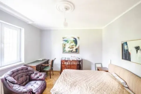 Furnished bedroom with a double bed, armchair, and a desk. - image 4