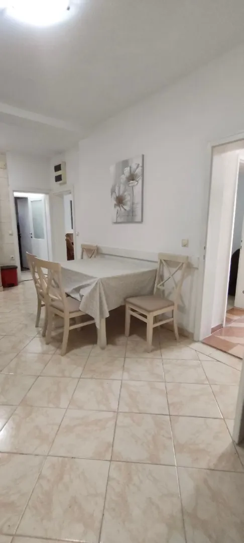 Dining area with a table and chairs in light tones.