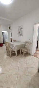 Dining area with a table and chairs in light tones. - image 9
