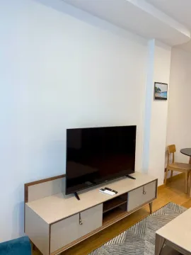 Living room with a TV on a media console and light walls. - image 5