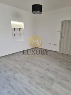 Empty room with light laminate flooring and built-in wall shelves. - image 8