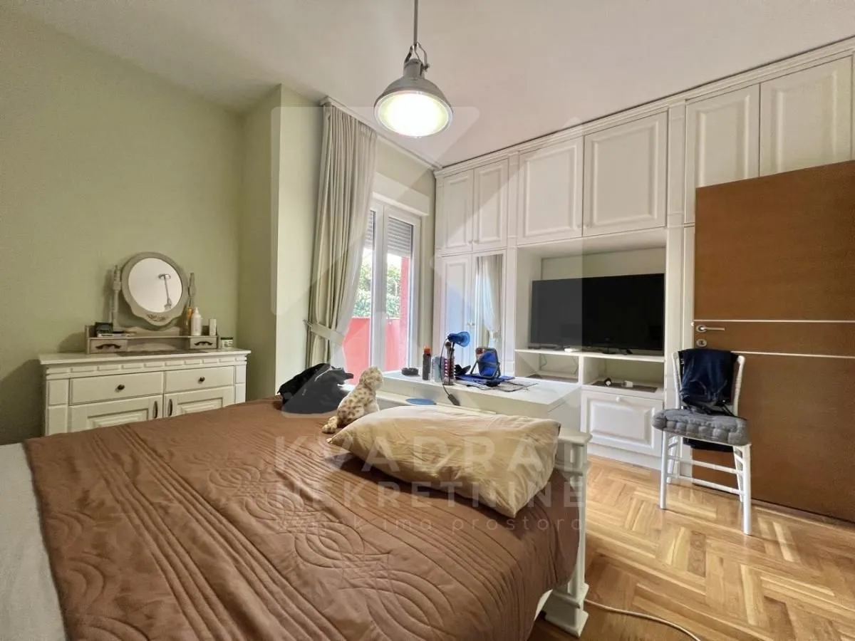 Furnished bedroom with a double bed, wardrobe, and television.