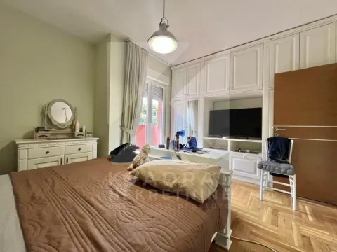 Furnished bedroom with a double bed, wardrobe, and television. - image 7
