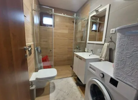 Savremeno opremljeno kupatilo sa tuš kabinom, umivaonikom i veš mašinom. - image 9