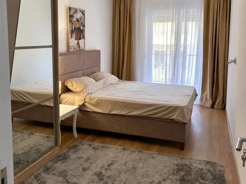 Uređena spavaća soba sa bračnim krevetom, velikim garderoberom sa ogledalom i prozorom sa zavjesama. - image 6