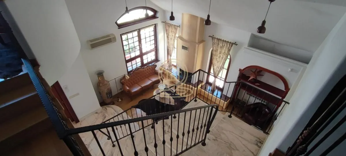 High-angle view of a spacious living room with a fireplace and staircase.