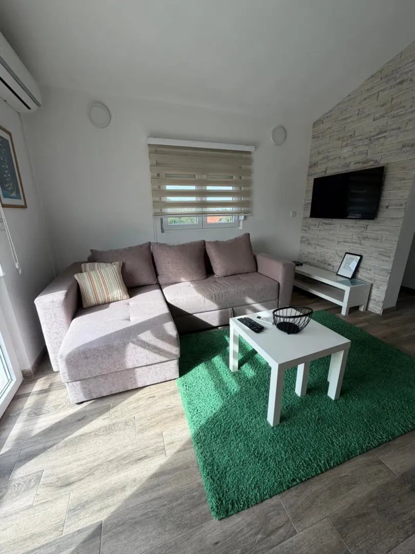 Living room with a sofa, coffee table, and TV.