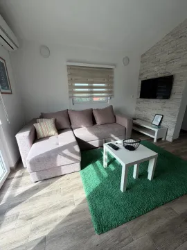 Living room with a sofa, coffee table, and TV. - image 2