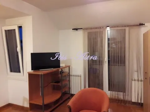 Living room with a TV, a TV unit, and an armchair. - image 3