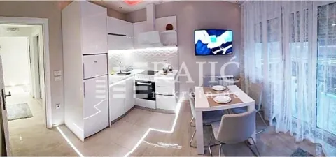 Modern white kitchen with a dining area and built-in appliances. - image 10
