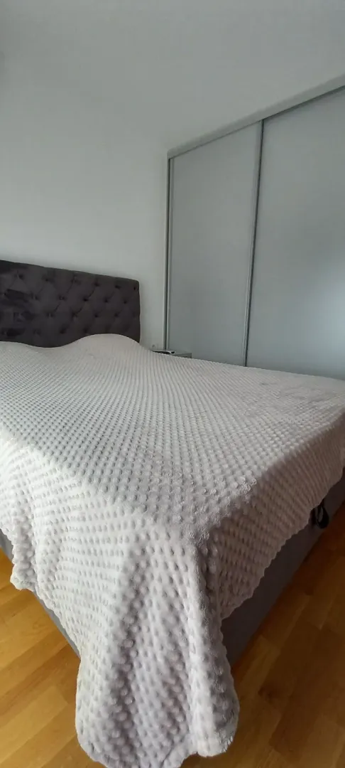 Bright bedroom with a large double bed and a built-in wardrobe.