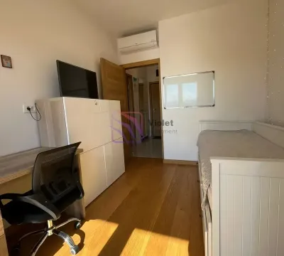 Manja spavaća soba sa krevetom, radnim stolom i televizorom. - image 5