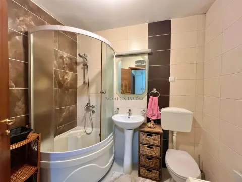 Bathroom equipped with a shower cabin, washbasin, and toilet. - image 11