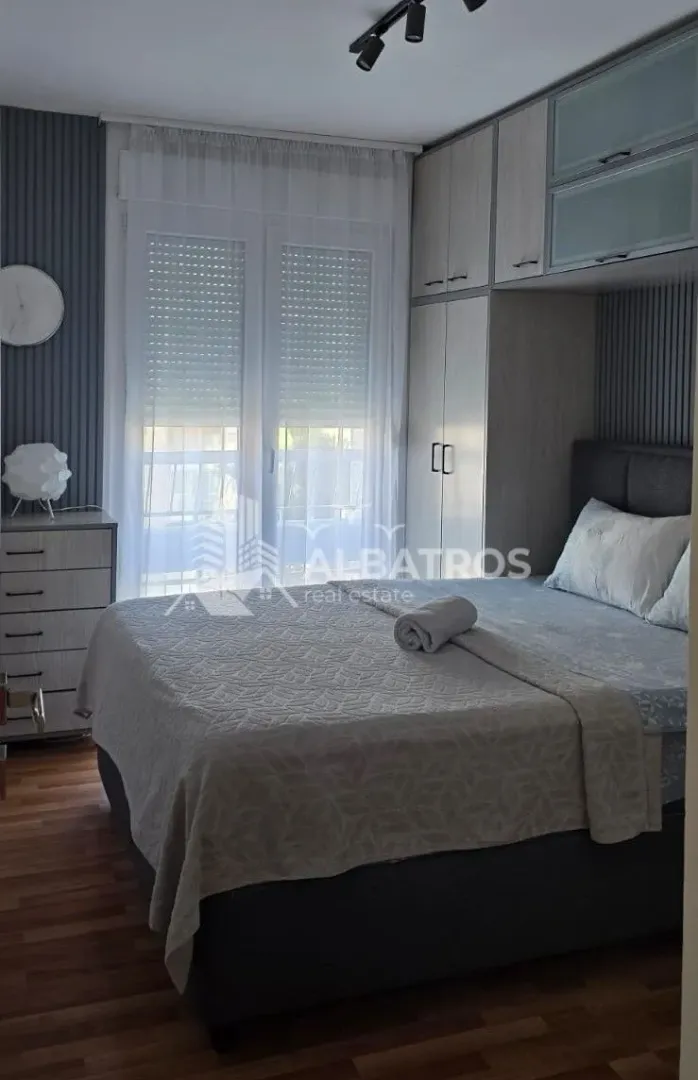 Furnished bedroom with a double bed, wardrobe, and a window.
