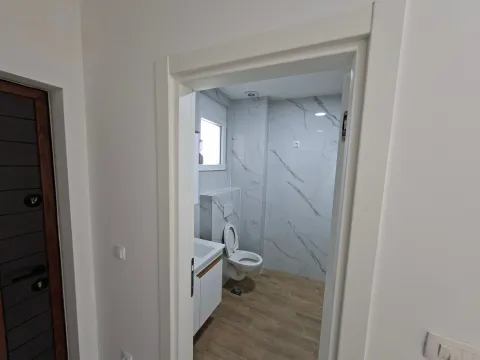 View from the hallway into a modern bathroom with bright tiles. - image 5