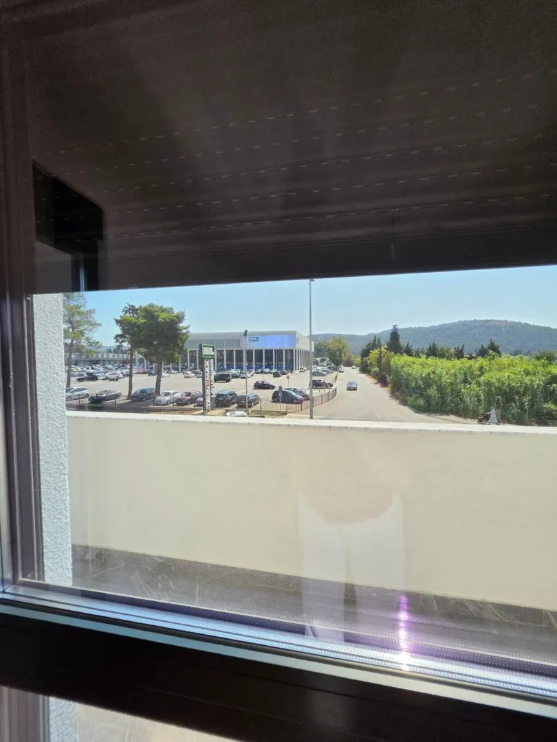 Pogled sa prozora na okolinu i parking.