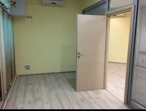 An empty room with light walls and laminate flooring, suitable for an office. - image 4