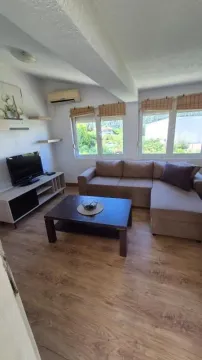 Living room with sofa, television and a coffee table by the window. - image 4