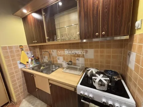 Compact kitchen with wooden cabinetry, a sink, and a stove. - image 7