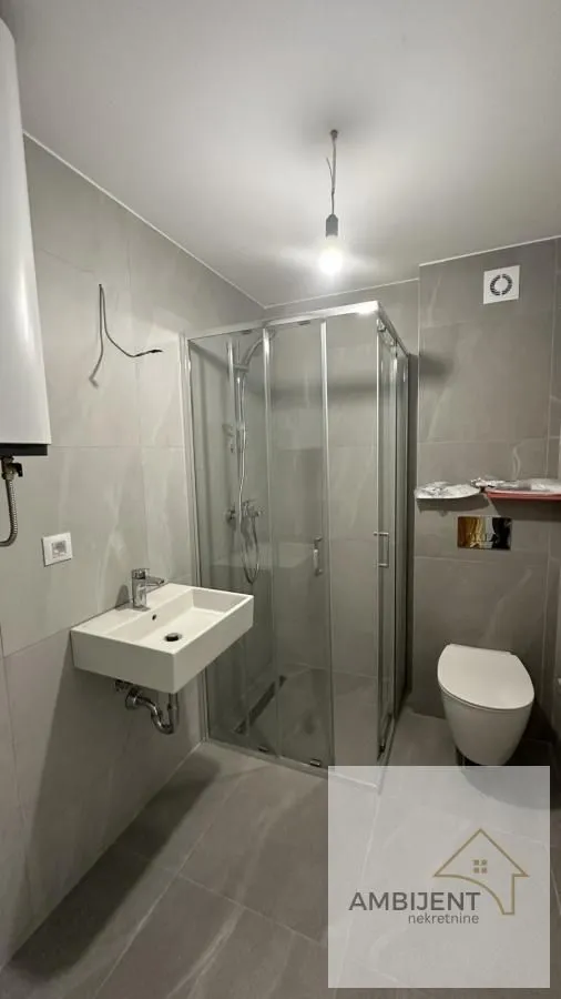 Novoopremljeno kupatilo sa tuš kabinom, umivaonikom i toaletom.