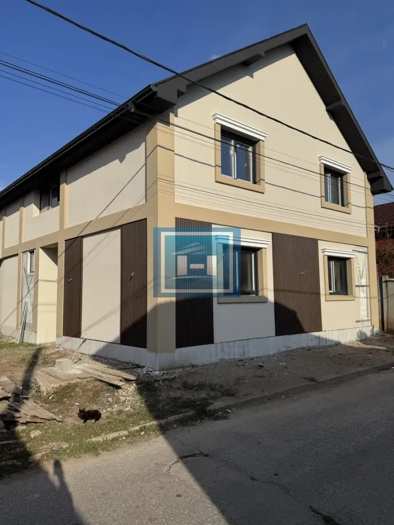 Pogled sa ulice na spoljašnjost nove kuće sa fasadom.
