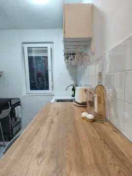 Pogled na drvenu radnu površinu u kuhinji sa sudoperom, aparatima i prozorom. - image 4