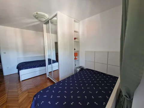 Spavaća soba sa dva kreveta i bijelim garderoberom sa ogledalom. - image 9