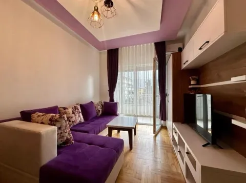 Living room with a purple sofa set and a TV unit. - image 4