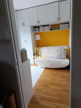Smaller bedroom with a fold-out bed, wardrobes, and a yellow wall. - image 5