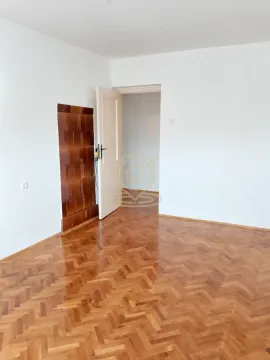 Prazna prostorija sa parketom i otvorenim vratima. - image 3