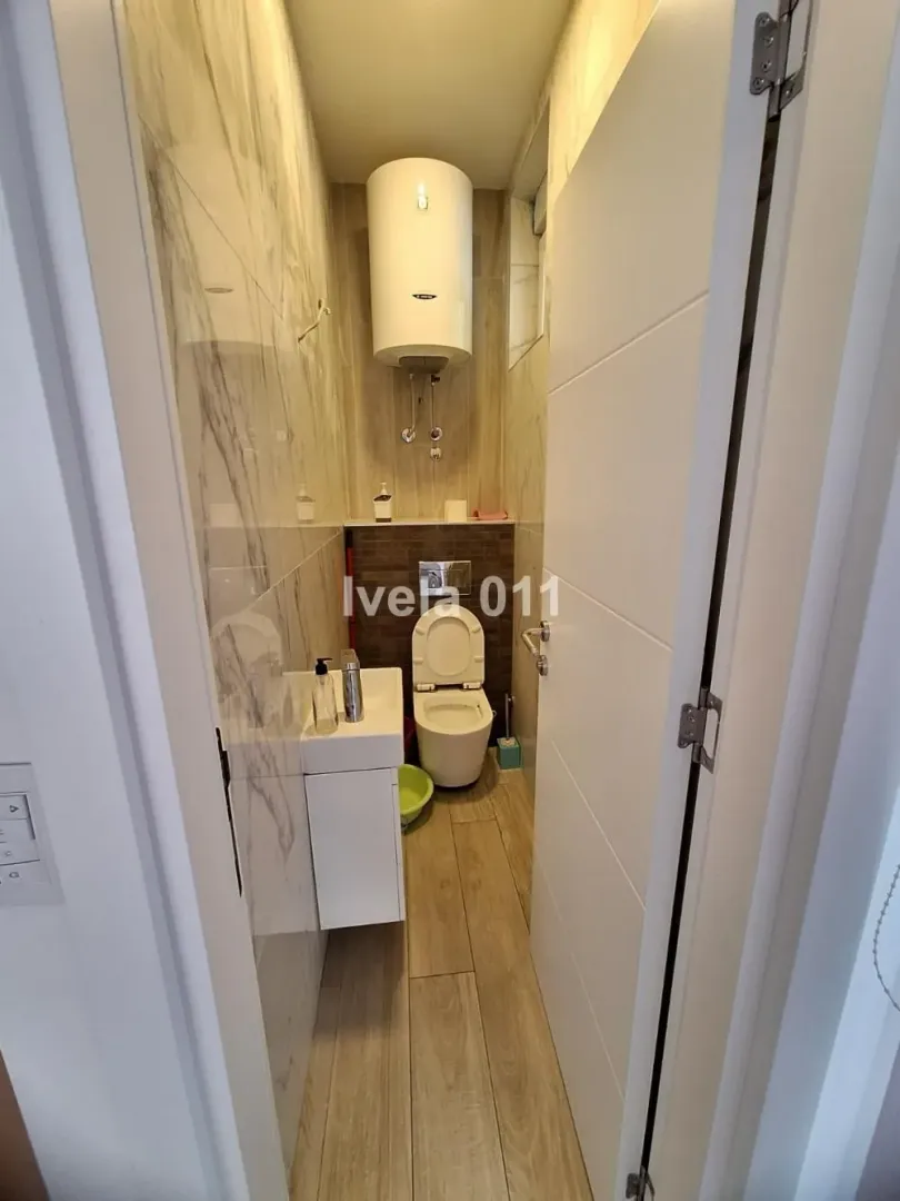 Small bathroom with a toilet, washbasin, and boiler.