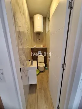 Small bathroom with a toilet, washbasin, and boiler. - image 5