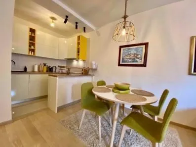 Modern kitchen with dining area and bright cabinetry.