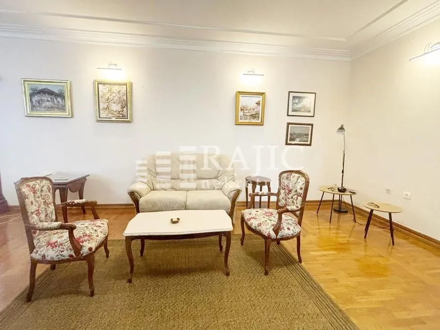 Living room with seating furniture and paintings on the wall.