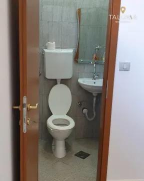 Small bathroom with a toilet, washbasin, and mirror. - image 2